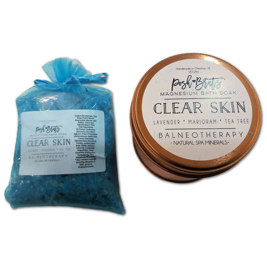 Displayed are two products: a bag and tin of Clear Skin Magnesium Aromatherapy Bath Salt by Posh Brats. Infused with lavender, marjoram, and tea tree oils, the blue salts feature natural spa minerals.