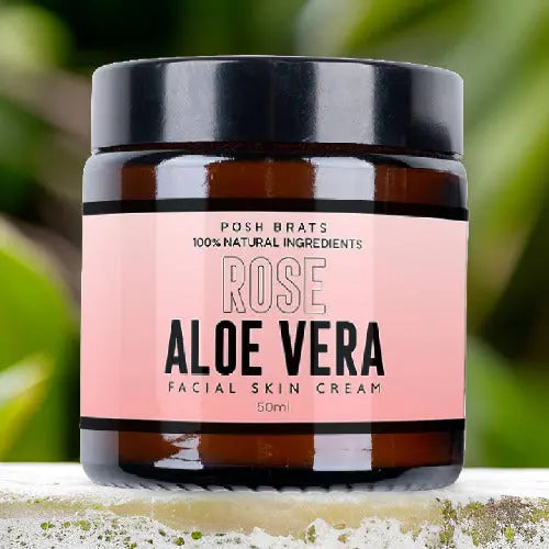 A 50ml jar of Posh Brats Rose Aloe Vera Skin Cream sits against a blurred green backdrop. Its label emphasizes 100% Natural Ingredients, promoting anti-inflammatory benefits for a radiant complexion.