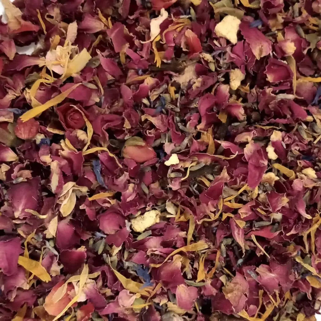 The Wildcraft Botanical Potpourri by Posh Brats showcases a vibrant, close-up mix of dried red, pink, and yellow petals with green leaves and fragrant herbs, creating an aromatic tapestry.