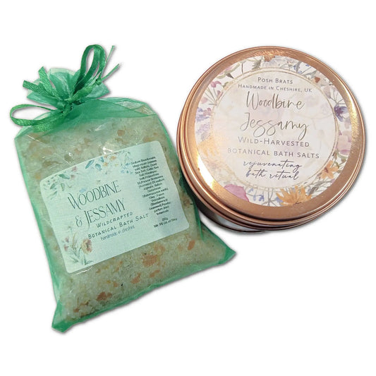 The green mesh bag includes Posh Brats Woodbine Jessamy Botanical Bath Salt from Cheshire, UK, next to a round tin. These items promise relaxation with natural, rejuvenating ingredients.