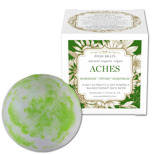 The green and white Aches Aromatherapy Bath Bomb by Posh Brats offers natural, organic muscle relief. Crafted in Cheshire, UK, its infused with essential oils like rosemary, thyme, and marjoram for a vegan bath experience.