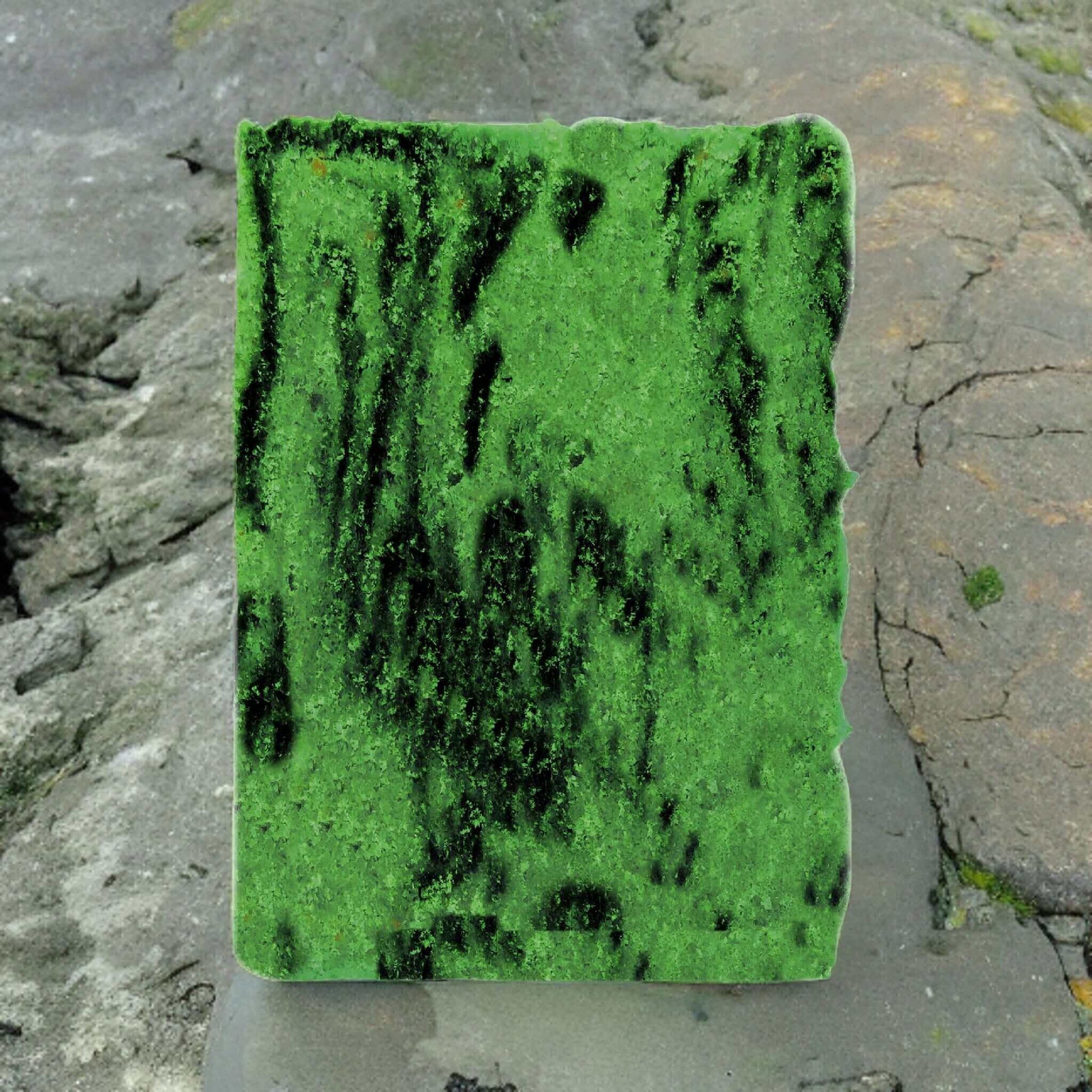 A Mystic Caledonian Forest Sugar Scrub Bar by Posh Brats, covered in green moss-like patterns with dark strokes, rests on a textured stone surface. Its vibrant look contrasts beautifully with the rocky background, capturing the essence of Scottish botanicals.