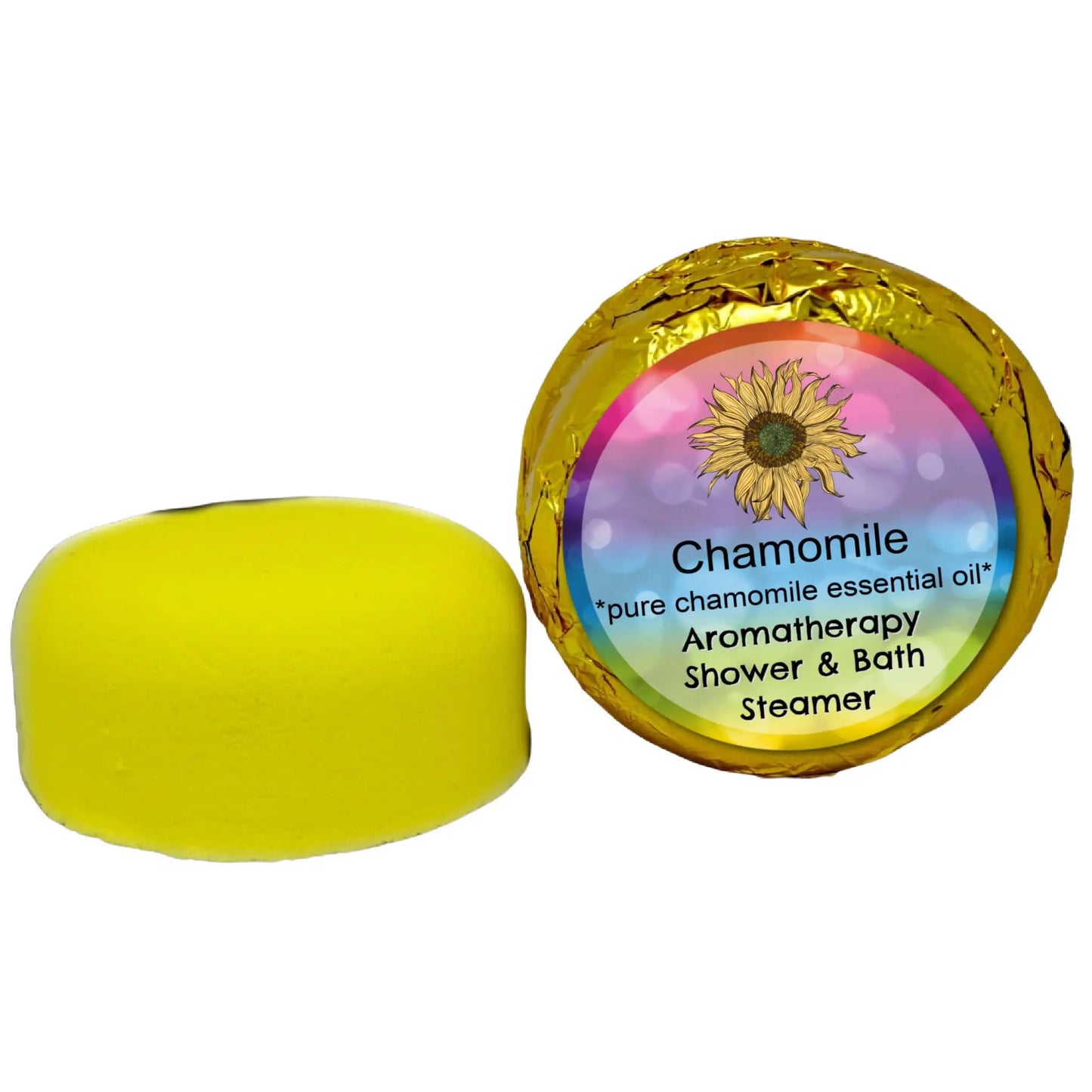 A yellow, round Chamomile Aromatherapy Shower Steamer by Posh Brats sits beside its sunflower-adorned golden foil wrapper, featuring the text: Chamomile Aromatherapy, pure chamomile essential oil, promising a soothing experience with each use.