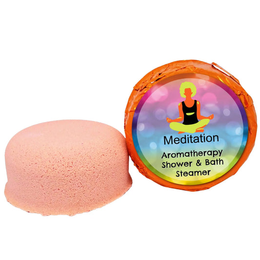 A pink shower steamer with essential oils sits next to its orange Meditation Aromatherapy Shower Steamer package by Posh Brats, featuring a meditating silhouette on a calming gradient background.