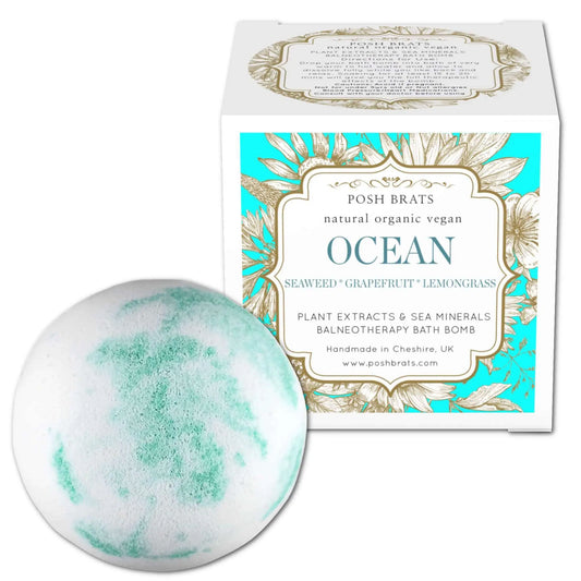 The Ocean Aromatherapy Bath Bomb by Posh Brats, featuring green and white swirls, sits next to its box. Infused with seaweed, grapefruit, and lemongrass essential oils, this natural organic vegan bath bomb is crafted in Cheshire, UK.