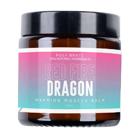 A brown jar with a black lid labeled Red Dragon Warming Balm Aromatherapy by Posh Brats features a gradient pink to teal design highlighting heat therapy, made with 100% natural ingredients and contains 50ml.