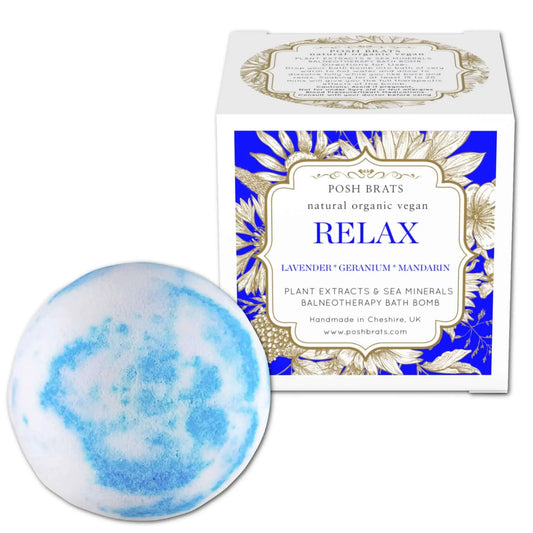 A blue and white Relax Aromatherapy Bath Bomb by Posh Brats, infused with stress-relieving lavender, geranium, and mandarin oils, sits beside its box featuring a floral design on a soothing blue background.