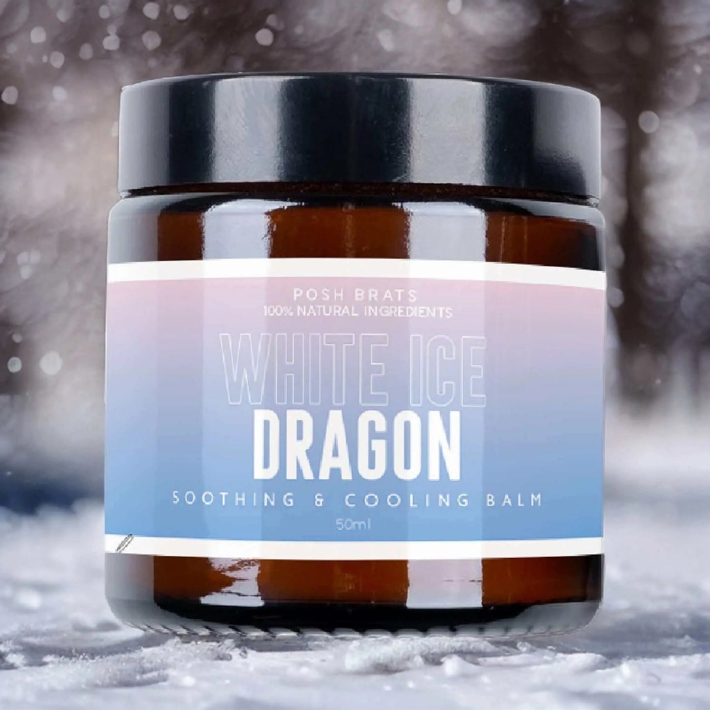 Posh Brats White Dragon Ice Aromatherapy Cooling Balm, made with 100% natural ingredients, provides cooling and soothing relief. The brown jar with a black lid stands against a blurred, snowy backdrop, highlighting its serene and refreshing essence.