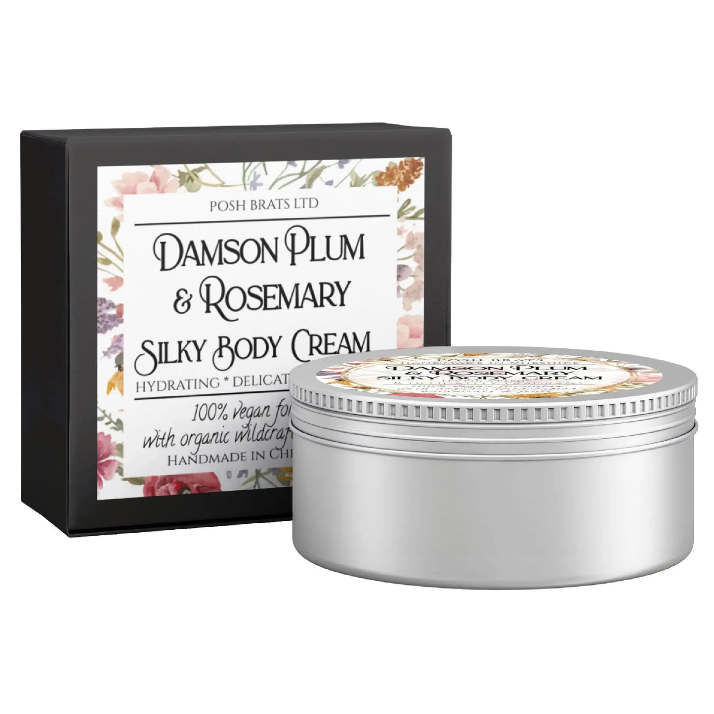 A round silver tin of Posh Brats Damson Plum + Rosemary Silky Body Butter Cream, featuring a floral label and highlighting its hydrating and vegan properties, stands next to its matching decorative box.