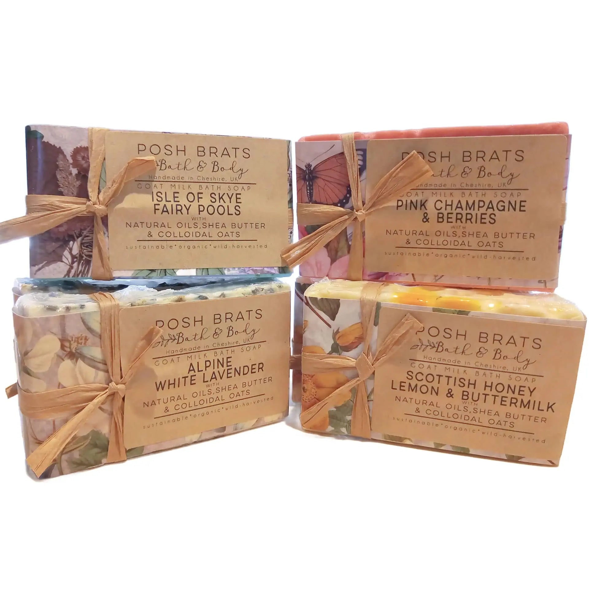 Two layers of four colorful Cold Process Castille Soap Bars by Posh Brats | Bath Body Skincare Home are tied with twine, featuring scents: Isle of Skye Fairy Pools, Pink Champagne & Berries, Alpine White Lavender, and Scottish Honey Lemon & Buttermilk. Enjoy luxurious cleansing with natural ingredients.