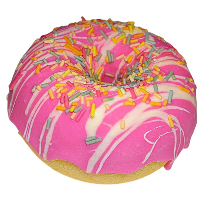 The Berry Vanilla Sprinkle Donut Bath Bomb by Posh Brats resembles a sweet treat with pink frosting, white icing drizzles, and vibrant sprinkles, offering a lavish bath experience.