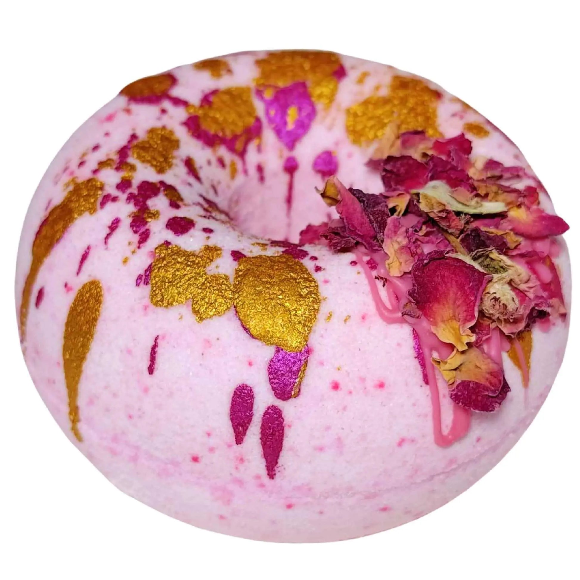 Introducing the Moonlight Kiss Donut Bath Bomb by Posh Brats: a pink doughnut-shaped delight accented with gold splashes and dried rose petals, featuring vibrant magenta drips. Indulge in a luxurious aromatic journey.